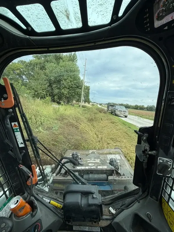 View from a skid steer cutting roadside vegetation